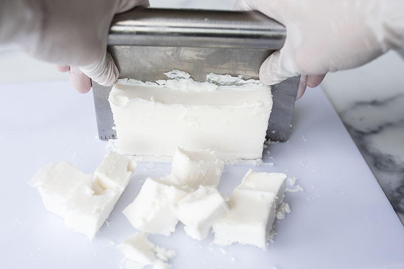 Cutting cosmetic soap base for shampoo into cubes.