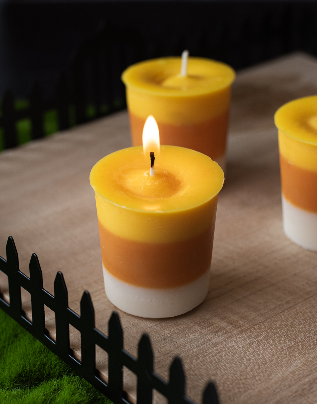 Votive candles dyed in layers of white, orange, and yellow to resemble candy corn.