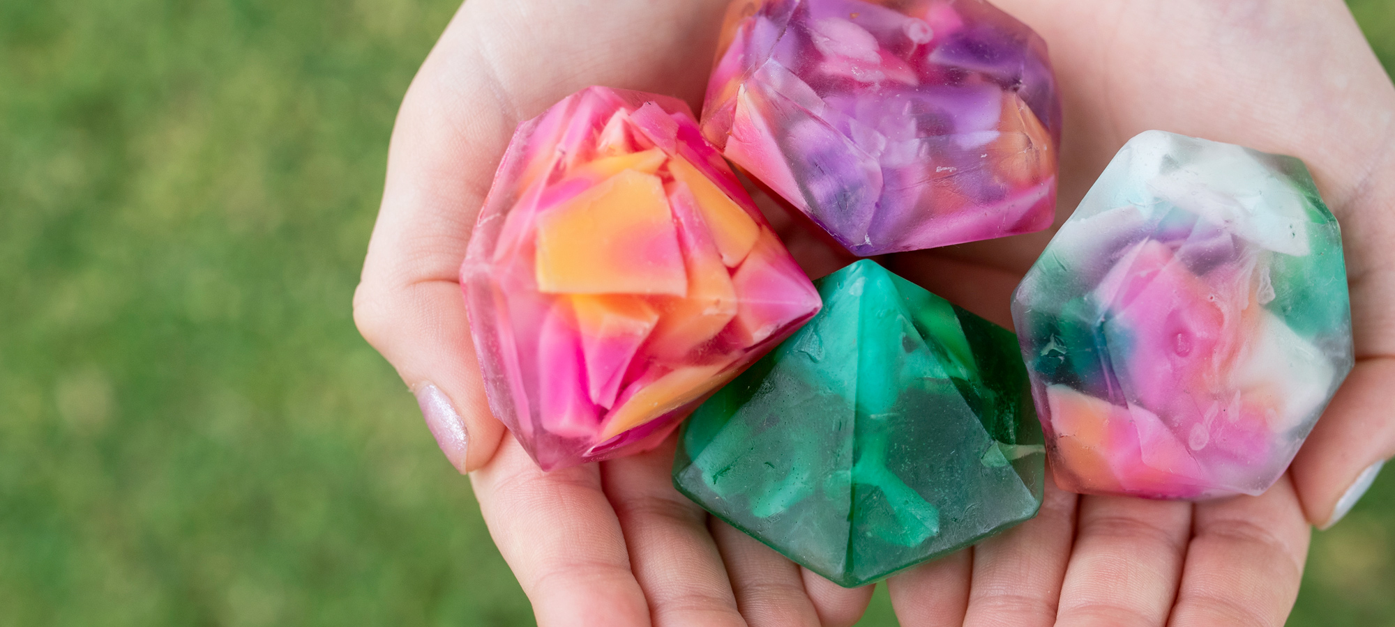 Hands holding colorful diamond shaped hand soaps